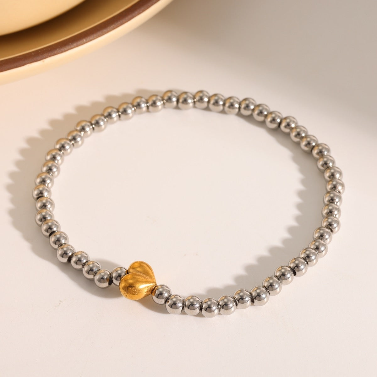 Pulsera plata con corazón dorado